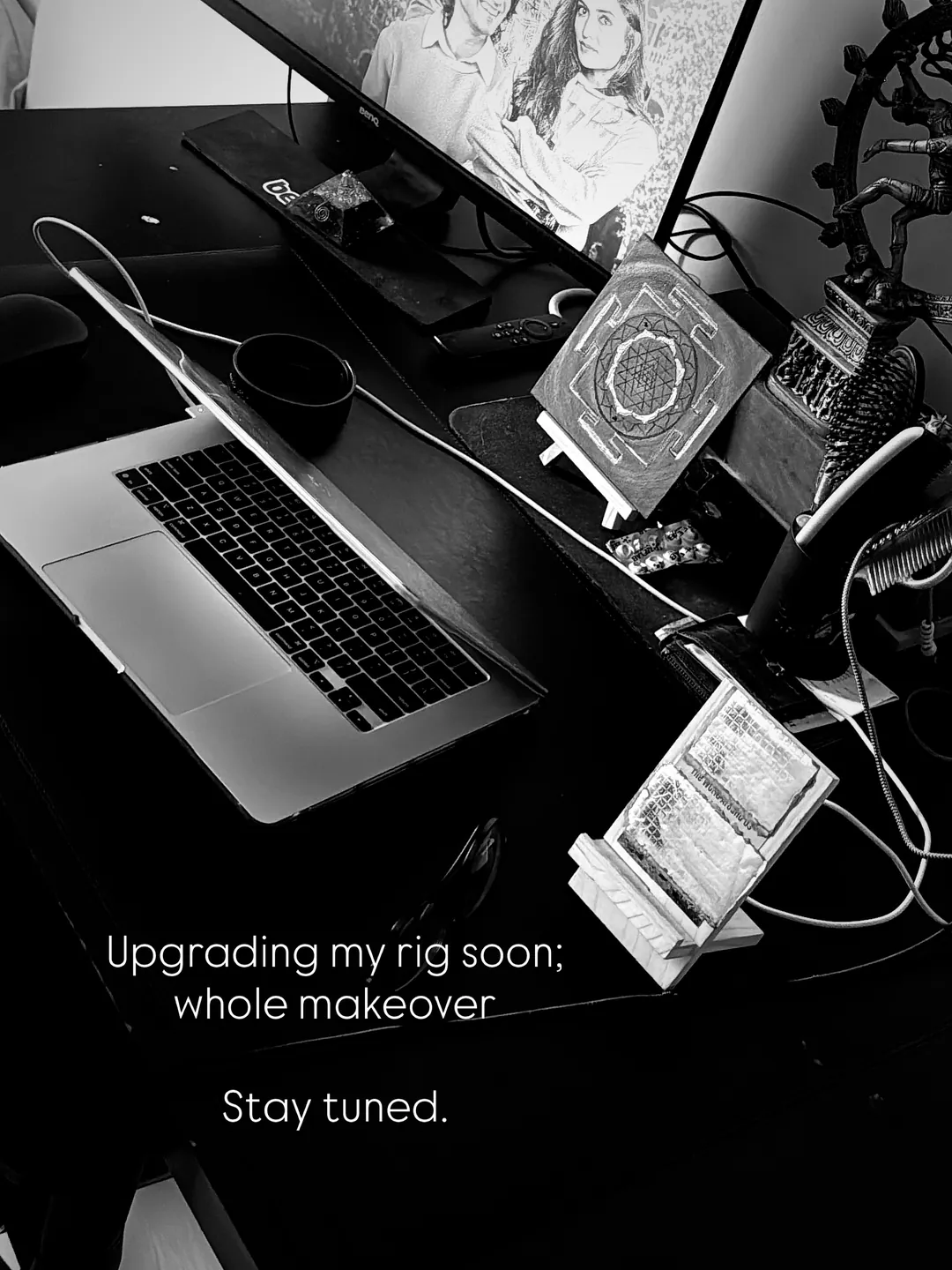 A desk with a laptop, monitor and books, captioned: upgrading my rig soon, whole makeover, stay tuned
